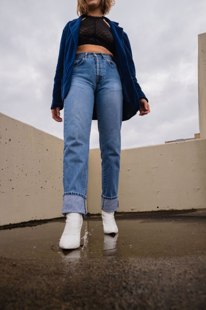 person in blue denim jeans and white boots
